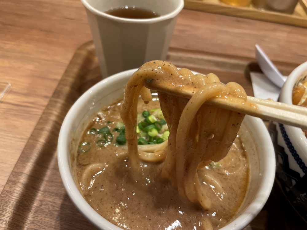 極太麺をスープに浸す